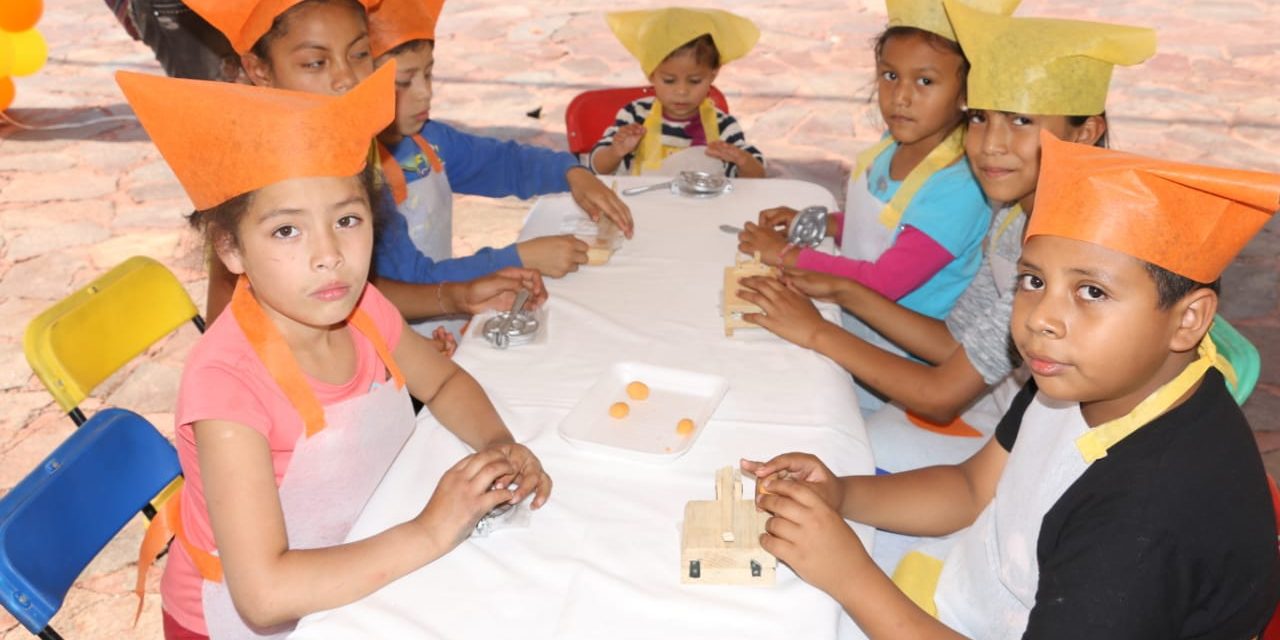 Niños participan en elaboración de tradicionales enchiladas.